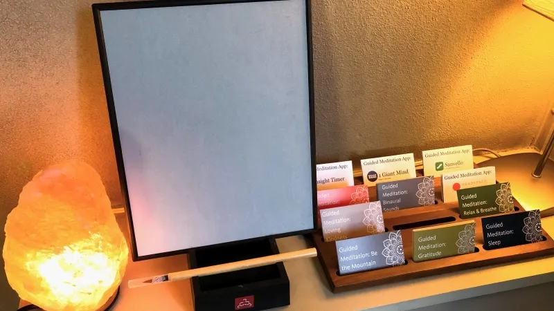 Buddha board on shelf between salt lamp and guided meditation card