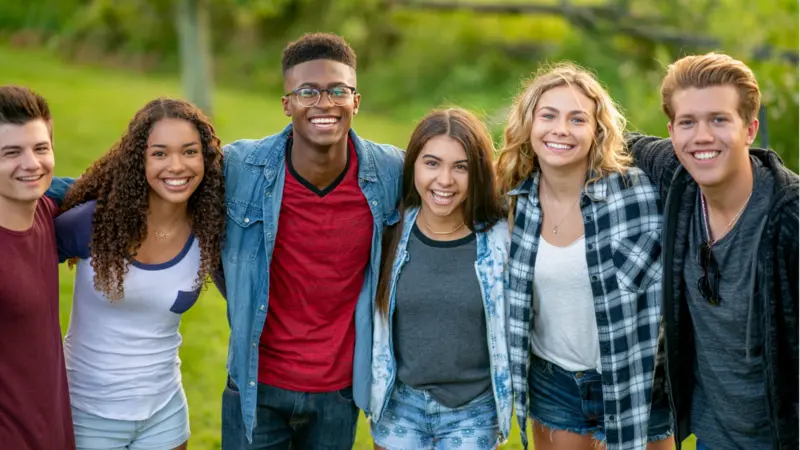 Diverse group of smiling young adults standing together