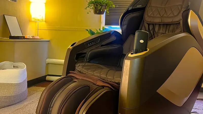 Full body massage chair in the Mind Spa with plants and soothing lamplight in the background
