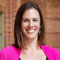 Erica Woekel posing for a photo outside a campus building