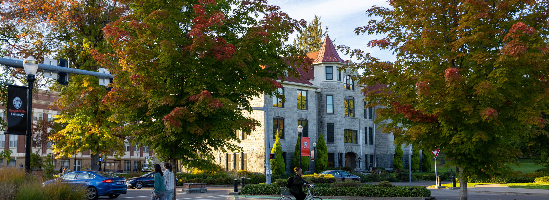 autumn trees on OSU campus with Furman Hall in background and students walking on sidewalks
