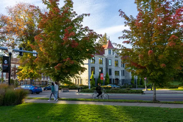 autumn trees on OSU campus with Furman Hall in background and students walking on sidewalks